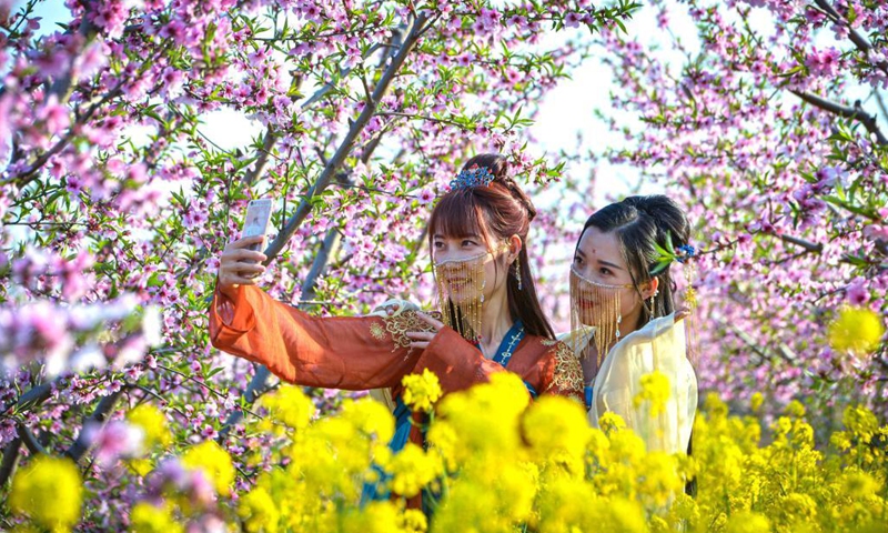 Tourists take selfies at a peach garden demonstration area in Nanbu Township of Handan City, north China's Hebei Province, April 4, 2021. Peach blossoms are in full bloom in Nanbu Township, attracting many tourists. (Xinhua/Wang Xiao)