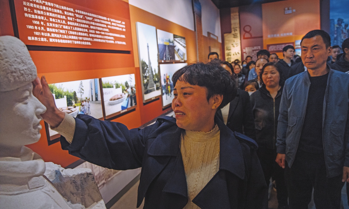Wang Zhuoran's mother Yang Suxiang touches the face of her son's statue in the martyrs' memorial. Photo: Li Hao/GT