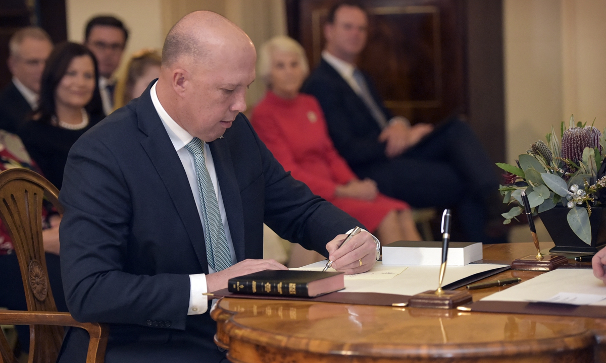 Australian then Minister for Home Affairs Peter Dutton signs documents during an oath taking ceremony at Government House in Canberra on May 29, 2019. Photo: AFP
