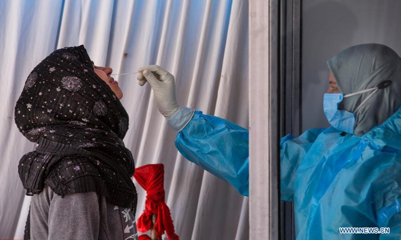 A health worker takes a nasal swab sample from a woman for COVID-19 test in Srinagar city, the summer capital of Indian-controlled Kashmir, April 5, 2021.(Photo: Xinhua)