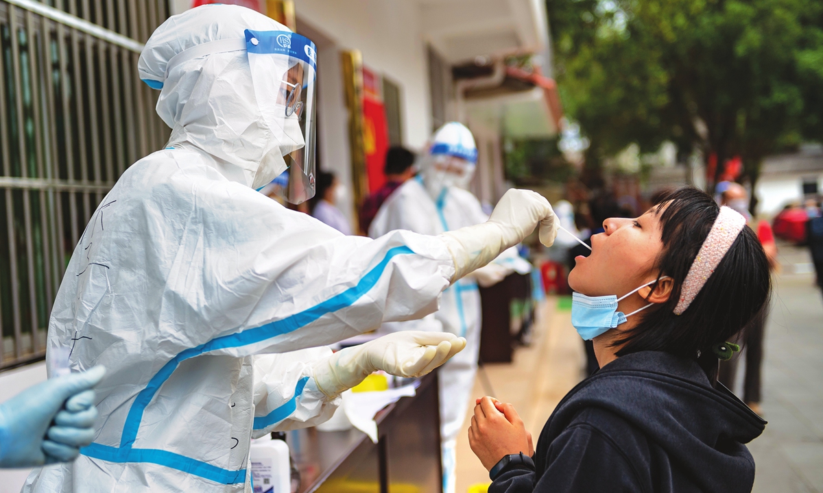 A medical worker collects a sample from a local resident in Ruili, Southwest China's Yunnan Province, for a nucleic acid test on Tuesday as the city launched a second round of mass testing. Photo:Xinhua
