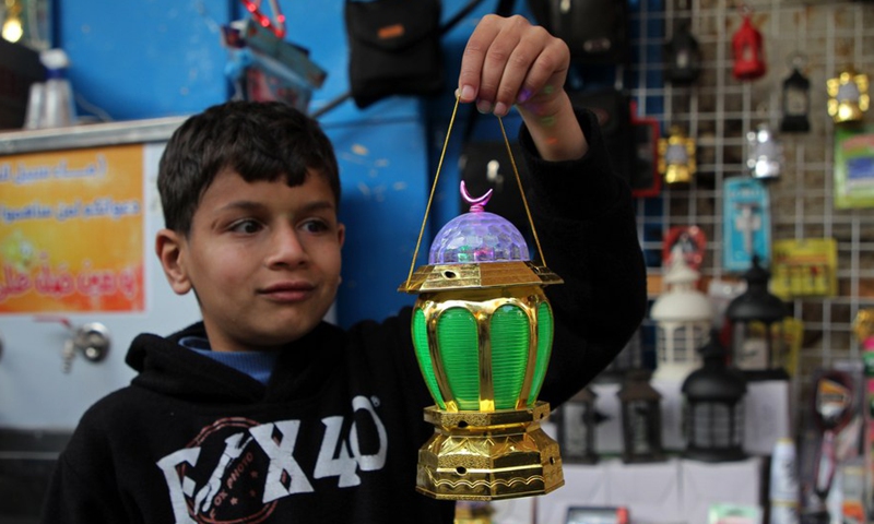 A Palestinian boy holds a Ramadan lantern at a market ahead of the Islamic holy month of Ramadan in Gaza City, on April 4, 2021.(Photo: Xinhua)