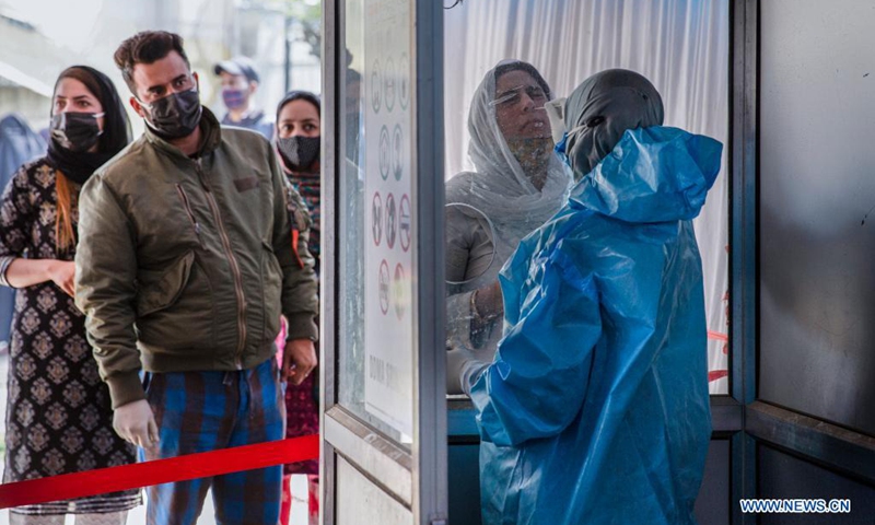 A health worker takes a nasal swab sample from a woman for COVID-19 test in Srinagar city, the summer capital of Indian-controlled Kashmir, April 5, 2021.(Photo: Xinhua)