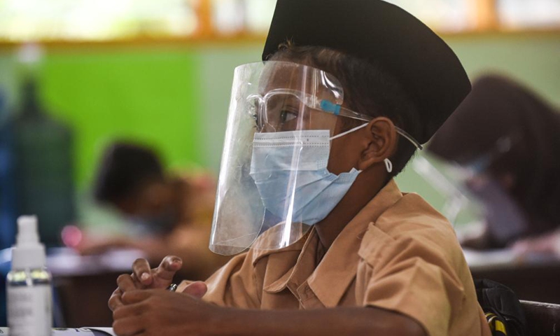 A student wearing a face mask and a face shield attends a class during the trial face-to-face learning at a school in Jakarta, Indonesia, April 7, 2021. Trial reopenings of 85 schools in Jakarta will start from April 7 to 29. The Indonesian government on March 30 asked schools to carry out limited offline (face to face) learning with parental consents and the implementation of health protocols.(Photo:Xinhua)