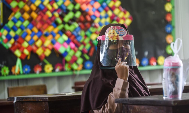 A student wearing a face mask and a face shield attends a class during the trial face-to-face learning at a school in Jakarta, Indonesia, April 7, 2021. Trial reopenings of 85 schools in Jakarta will start from April 7 to 29. The Indonesian government on March 30 asked schools to carry out limited offline (face to face) learning with parental consents and the implementation of health protocols. (Photo:Xinhua)