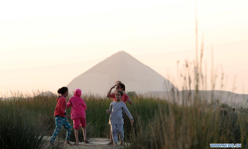 Children play near the Bent Pyramid in Giza, Egypt, April 5, 2021. The Bent Pyramid has a history of more than four thousand years, locating at Dahshur royal necropolis in Giza, south of Cairo. The pyramid was named as the Bent Pyramid or the Pyramid with Two Angles for having two different angles of inclination from base to top.(Photo: Xinhua)