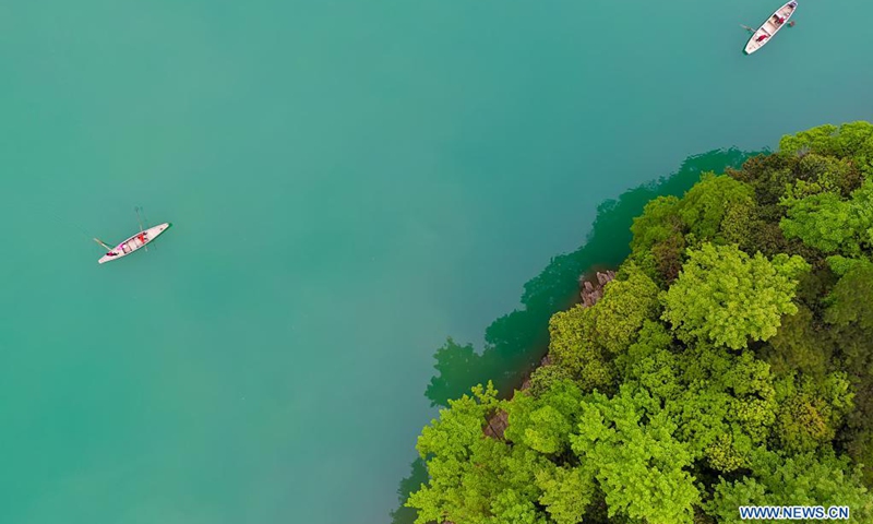 Aerial photo taken on April 7, 2021 shows volunteers patrolling the lake to keep the water clean in Wuzhuang Village of Chun'an County, east China's Zhejiang Province. Volunteers are encouraged to take part in the ecological environment protection in the county.(Photo: Xinhua)