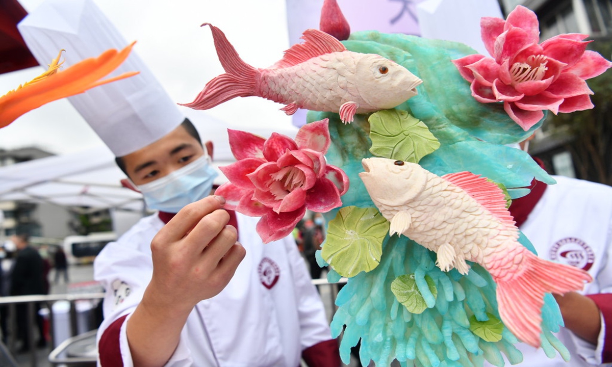 Chefs from Chengdu, Southwest China's Sichuan Province, showcase their knife skills once again, winning the grand prize in a competition with their two fish playing with lotus carved out of radish. Photo: IC