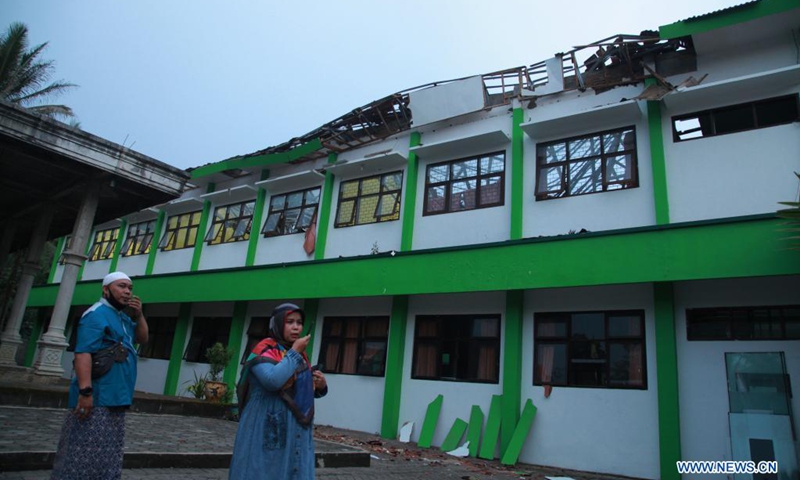 People stand near a damaged school building after a 6.1-magnitude quake in Malang, East Java, Indonesia, April 10, 2021. Six people were killed, another one was seriously injured, and scores of buildings were damaged after a 6.1-magnitude quake rocked Indonesia's western province of East Java on Saturday, officials said.(Photo: Xinhua)