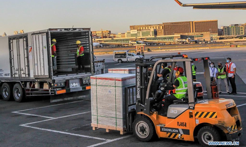 Staff members transport cargos containing the Sinovac COVID-19 vaccines in Manila, the Philippines on April 11, 2021. The Philippines on Sunday received the second batch of Sinovac Biotech's CoronaVac vaccines purchased from China. (Photo: Xinhua)