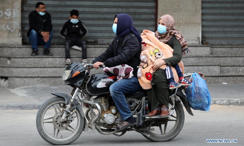 Palestinian people wearing face masks ride on a motorcycle in the southern Gaza Strip city of Khan Younis, April 10, 2021, amid strict measures imposed by the Hamas-run local authorities to curb the COVID-19 pandemic.(Photo: Xinhua)