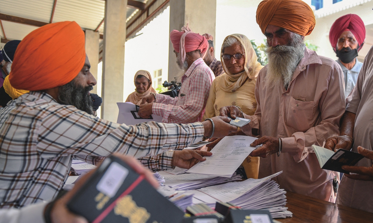 On Sunday, Sikh pilgrims  at the Golden Temple complex in Amritsar, India, collect their passports from Shiromani Gurdwara Parbandhak Committee officials, as they expect to head to Pakistan to celebrate Baisakhi festival. Pakistan has issued more than 1,100 visas to Sikh pilgrims from India to participate in the annual Baisakhi celebrations, which are planned to last from Monday to April 22. Photo: AFP