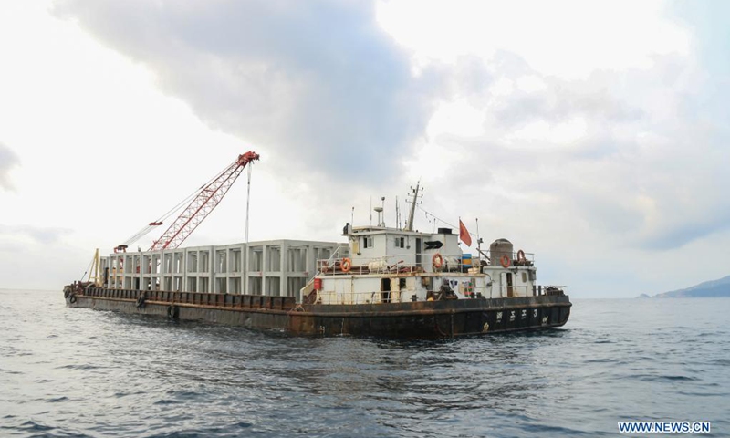 Photo taken on April 1, 2021 shows the vessel transporting artificial reefs near Wuzhizhou Island in Sanya City, south China's Hainan Province. Wuzhizhou Island has launched a comprehensive drive to build a marine ranch and restore the marine ecosystem, by placing artificial reefs under the sea and transplanting corals. By the end of 2020, Wuzhizhou Island marine ranch has placed 1,526 artificial reefs. And 870 more will be laid within a month in the recent artificial reefs placement. (Photo: Xinhua)