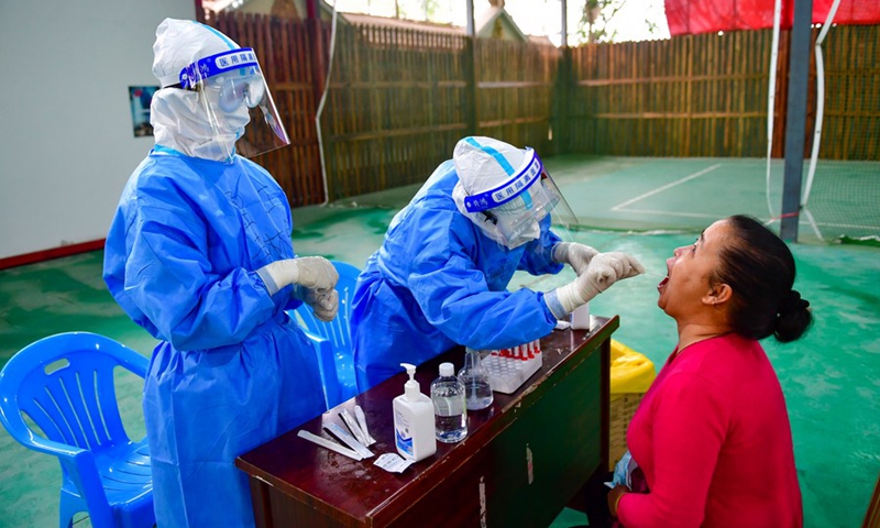 A medical worker takes a swab sample from a woman for COVID-19 testing at a testing site in Ruili City, southwest China's Yunnan Province, April 6, 2021.(Photo: Xinhua)