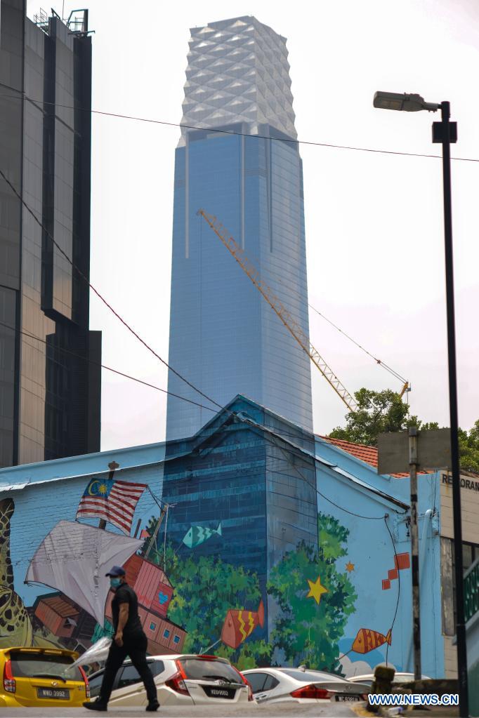 A pedestrian walks near a mural seamlessly melted with the Exchange 106 tower in the background in Kuala Lumpur, Malaysia, April 15, 2021. Photo: Xinhua