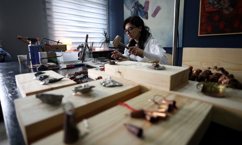 A Palestinian Rawan Raafat from East Jerusalem manufactures traditional Palestinian jewelry at her own shop on April 12, 2021.(Photo: Xinhua)