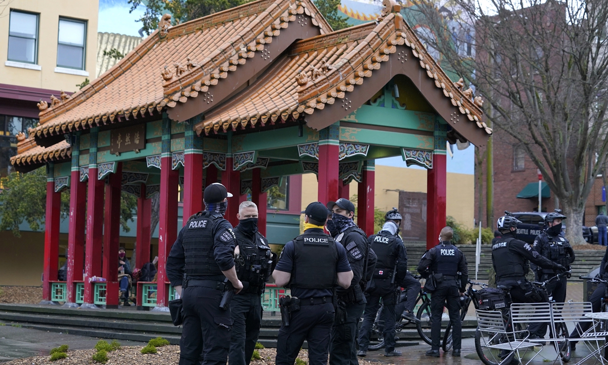 Seattle Police officers confer after taking part in a public roll call at Hing Hay Park in the heart of Seattle's Chinatown-International District Thursday, March 18, 2021, at the start of their shift as part of a community response unit. Photo: VCG
