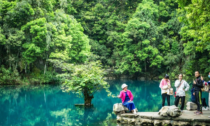 Tourists pose for photos at Xiaoqikong scenic spot in Libo County, southwest China's Guizhou Province, April 15, 2021. Photo: Xinhua