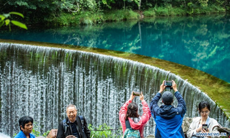 Tourists take photos at Xiaoqikong scenic spot in Libo County, southwest China's Guizhou Province, April 15, 2021. Photo: Xinhua