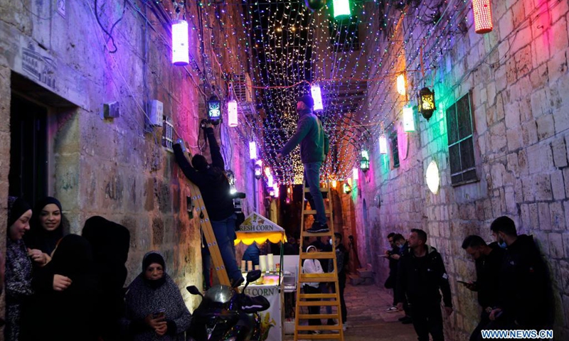 A man installs light decoration near the entrance of the Al-Aqsa Mosque compound in Jerusalem's Old City ahead of the holy month of Ramadan on April 11, 2021.(Photo: Xinhua)