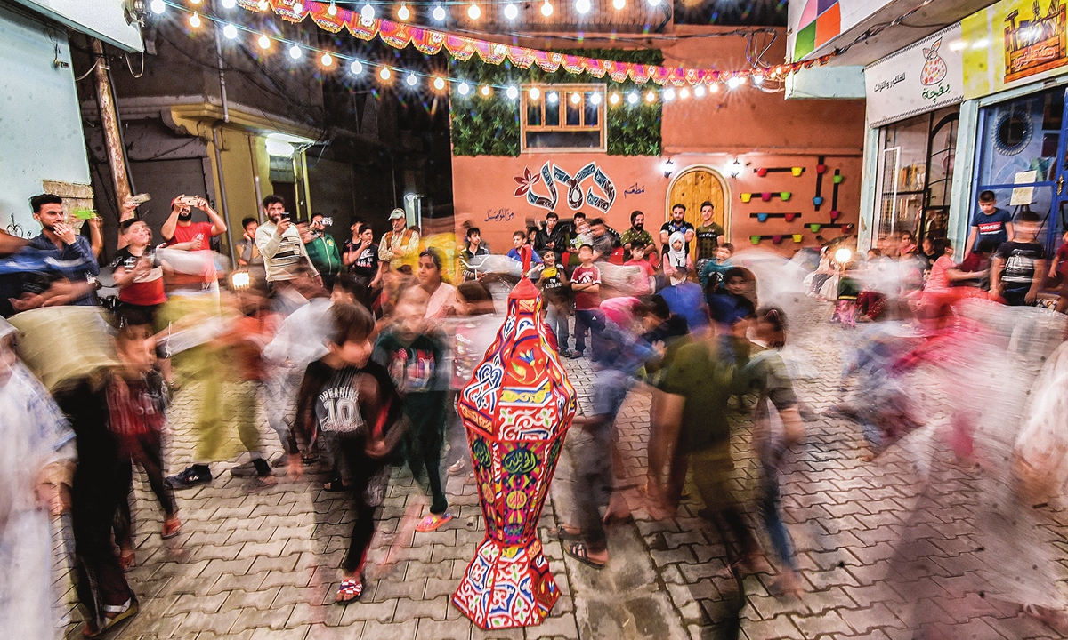 On Tuesday, children dance around a lantern during a street celebration hosted by a local cultural NGO on the first night of the Muslim holy fasting month of Ramadan in the old town of Iraq's northern city of Mosul, Iraq. Ramadan 2021 begins on Tuesday and will end on May 12. Photo: AFP

