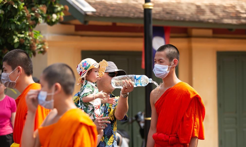 People sprinkle water to a monk during a parade celebrating the Songkran Festival or the Lao New Year in Luang Prabang, Laos, April 15, 2021.Photo: Xinhua