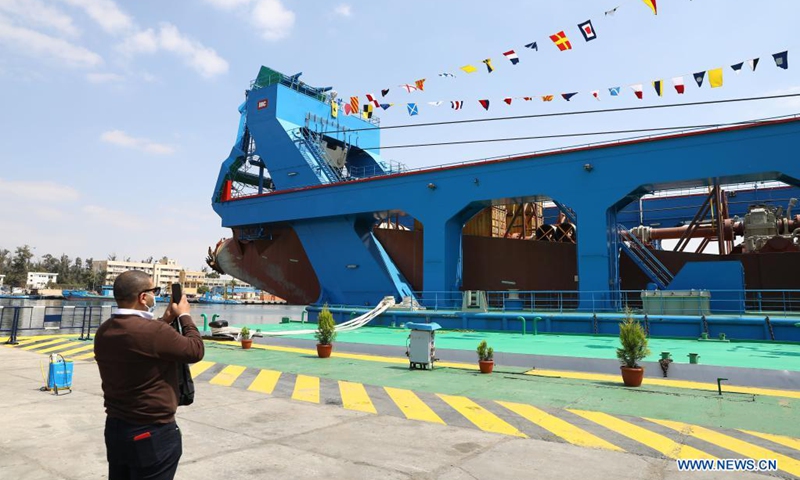 A man takes photos of a large cutter suction dredger (CSD) on Timsah Lake in Ismailia, Egypt, on April 12, 2021. Egypt's Suez Canal Authority (SCA) celebrated on Monday the recent arrival of the large cutter suction dredger (CSD).(Photo: Xinhua)