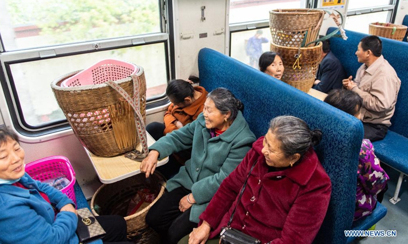 Passengers talk on the train 7265 after they sold out their vegetables in central China's Hunan Province, April 11, 2021. The 7265/7266/7267 trains started operation back in 1995, stretching more than 300 kilometers from Huaihua Station to Lixian Station. The trains pass 37 stops along the way in 9 hours and 16 minutes.