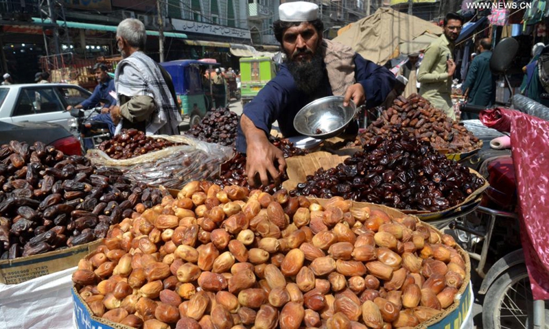 A vendor arranges dates at a market ahead of Muslim's fasting month of Ramadan in northwest Pakistan's Peshawar on April 13, 2021. The Ramadan crescent moon was sighted in Pakistan on Tuesday evening and the holy month will officially begin on Wednesday, according to an official announcement from the country's moon-sighting committee.(Photo: Xinhua)
