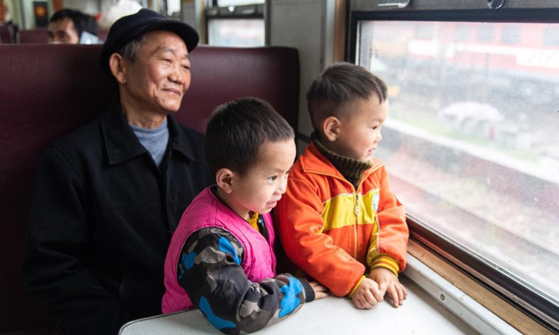 Passengers look out of the train 7266 in central China's Hunan Province, April 11, 2021. The 7265/7266/7267 trains started operation back in 1995, stretching more than 300 kilometers from Huaihua Station to Lixian Station. The trains pass 37 stops along the way in 9 hours and 16 minutes. The ticket prices range from 1 yuan to 23.5 yuan(about 0.15-3.59 U.S. dollars), which have not been raised in 26 years. 