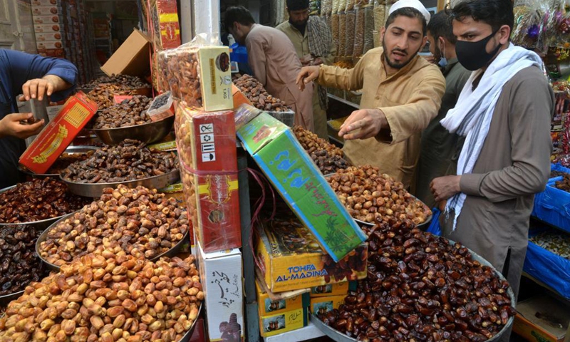 People buy dates at a market ahead of Muslim's fasting month of Ramadan in northwest Pakistan's Peshawar on April 13, 2021. The Ramadan crescent moon was sighted in Pakistan on Tuesday evening and the holy month will officially begin on Wednesday, according to an official announcement from the country's moon-sighting committee.(Photo: Xinhua)