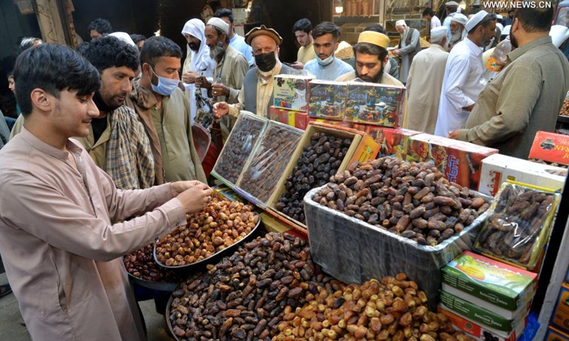 People buy dates at a market ahead of Muslim's fasting month of Ramadan in northwest Pakistan's Peshawar on April 13, 2021. The Ramadan crescent moon was sighted in Pakistan on Tuesday evening and the holy month will officially begin on Wednesday, according to an official announcement from the country's moon-sighting committee.(Photo: Xinhua)