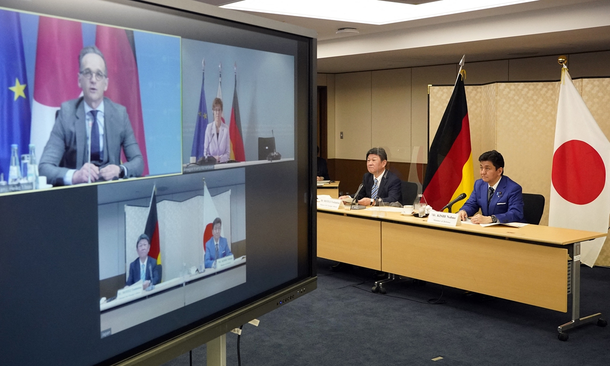 Japan's Foreign Minister Toshimitsu Motegi (2-R) and Defence Minister Nobuo Kishi (R) attend a video conference with German Foreign Minister Heiko Maas (top L, on screen) and Defence Minister Annegret Kramp-Karrenbauer (top R, on screen) at the Foreign Ministry in okyo on April 13, 2021. Photo: AFP