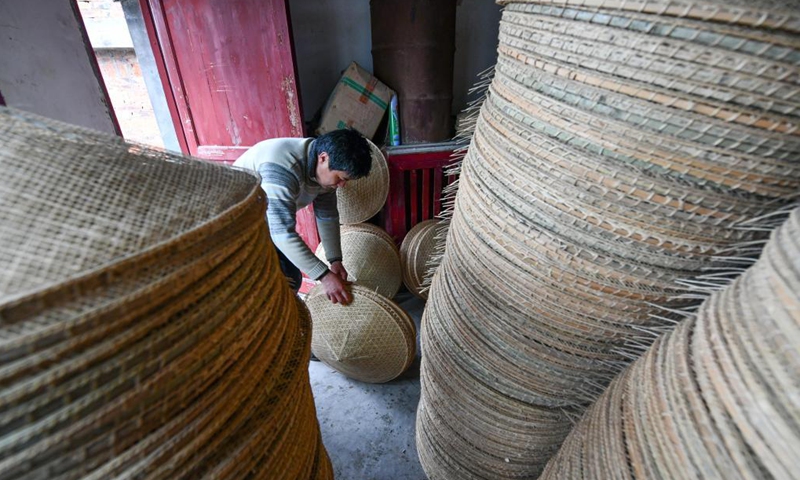 A villager arranges bamboo hats at a bamboo hat workshop in Shangjie Village of Sansui County, southwest China's Guizhou Province, April 11, 2021. With over 400-year of bamboo hat making history, Sansui County has taken the development of bamboo hat industry to enrich the people living there. (Xinhua)