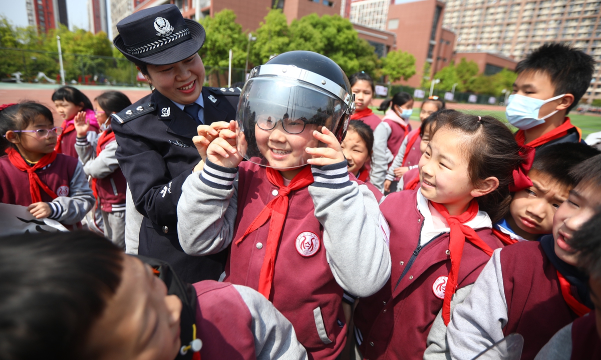 A police officer teaches primary school students about everyday safety and encourages them to try protection equipment in Nanjing, East China's Jiangsu Province on Thursday. Photo: cnsphoto