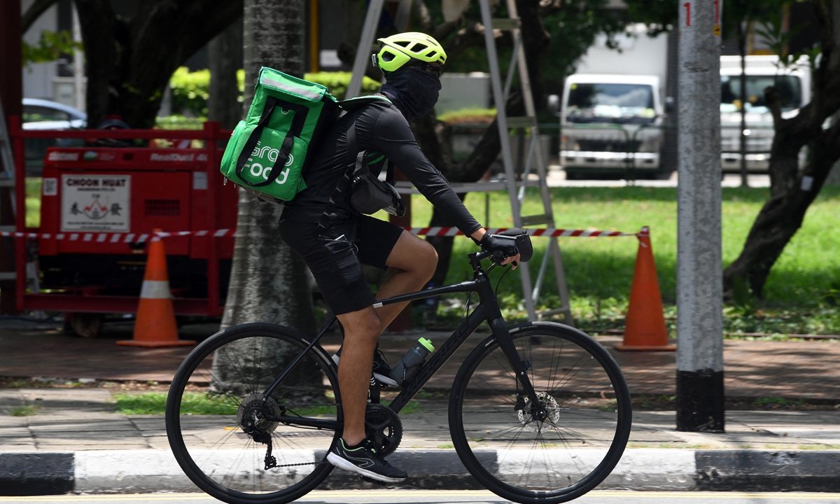 A Grab food delivery man rides along the pavement at Raffles Place in Singapore on September 15, 2020. Photo: AFP