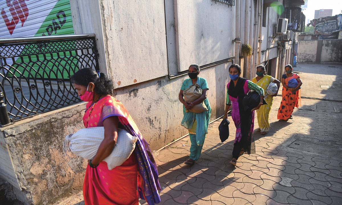 Lijjat Papad members carry freshly made dough to make papadums in Mumbai, India, on March 8. Photo: AFP