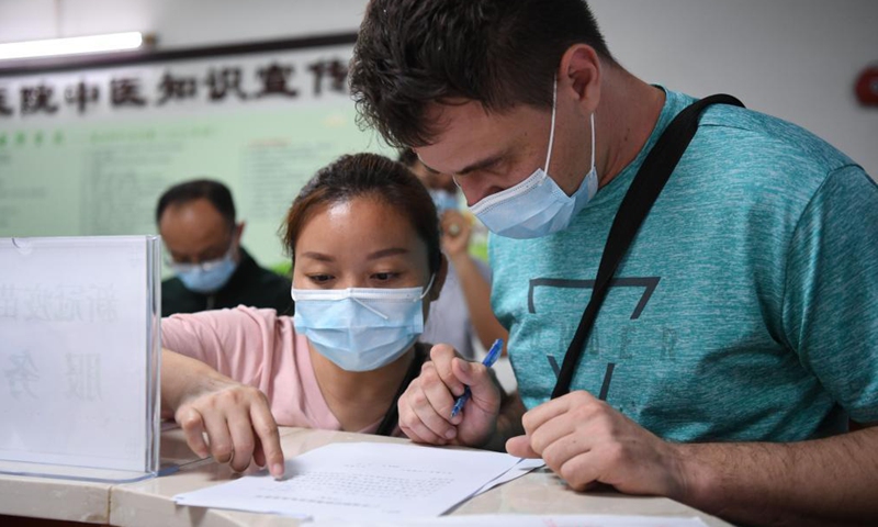 A Russian national (1st, R) registers for COVID-19 vaccination at a hospital in Yuexiu District of Guangzhou, south China's Guangdong Province, April 15, 2021.Photo:Xinhua