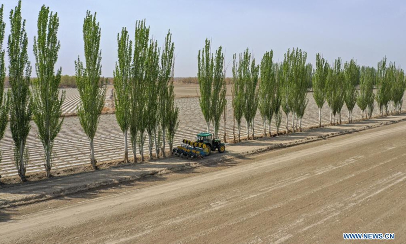 Aerial photo taken on April 13, 2021 shows a film mulching sower at work in a cotton field in Tungqeka Village of Xingping Township, Yuli County, Bayingolin Mongolian Autonomous Prefecture, northwest China's Xinjiang Uygur Autonomous Region.Photo:Xinhua