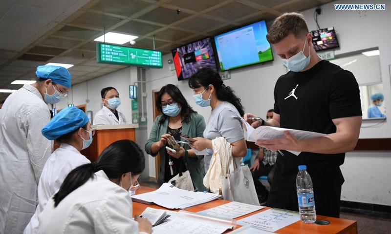 A Ukrainian national (1st, R) registers for COVID-19 vaccination at a hospital in Yuexiu District of Guangzhou, south China's Guangdong Province, April 15, 2021.Photo:Xinhua