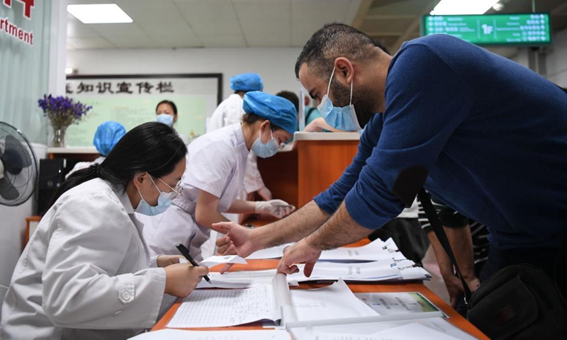 A Tunisian national (1st, R) registers for COVID-19 vaccination at a hospital in Yuexiu District of Guangzhou, south China's Guangdong Province, April 15, 2021. Photo:Xinhua