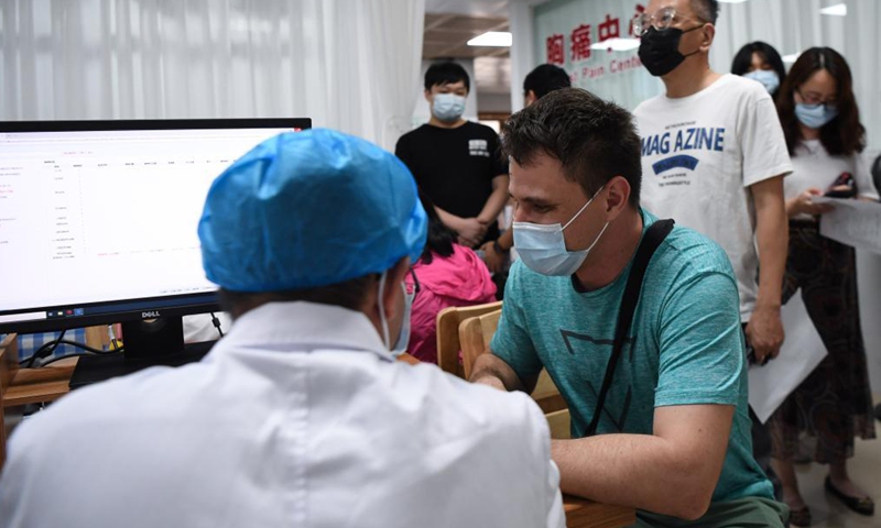 A medical worker checks people's medical history for COVID-19 vaccination at a hospital in Yuexiu District of Guangzhou, south China's Guangdong Province, April 15, 2021. Guangdong Province started administering COVID-19 vaccines to foreigners in the province on April 15 on a voluntary basis. Photo:Xinhua