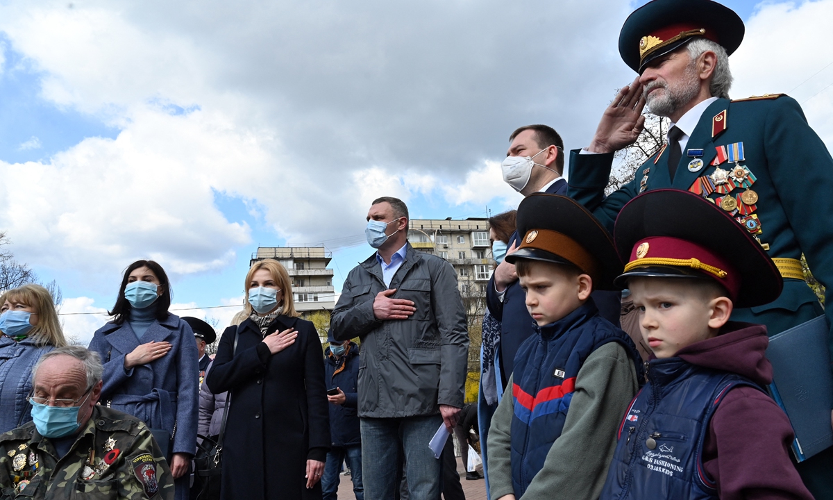 People gather at the Chernobyl memorial in Kiev to remember the victims of the nuclear accident on its 35th anniversary, on Monday in Ukraine. At that time, many Soviet people sacrificed their lives to minimize the aftermath of the disaster, which has been frequently cited recently to compare  with Japan's plan to dump Fukushima nuclear-contaminated  wastewater into the ocean. Photo: AFP