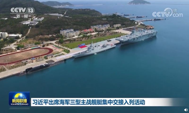The Chinese People's Liberation Army Navy commissioned three new warships, namely a Type 09IV nuclear-powered ballistic missile submarine, the Changzheng 18 (left), a Type 055 large destroyer, the Dalian (center), and a Type 075 amphibious assault ship, the Hainan, in Sanya, South China's Hainan Province on April 23, 2021. Three more Type 09IVs can be seen in the background. Photo: Screenshot from China Central Television