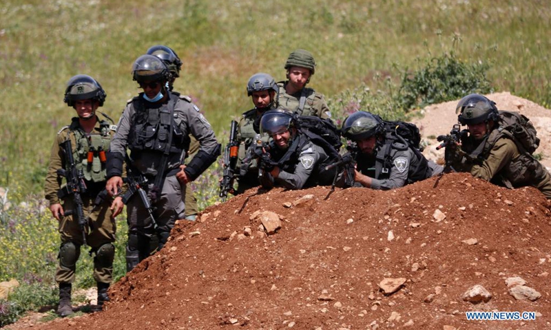 Members of the Israeli border police and Israeli soldiers are seen during clashes following a protest against the expansion of Jewish settlements in the West Bank village of Beit Dajan, east of Nablus, on April 16, 2021.(Photo: Xinhua)