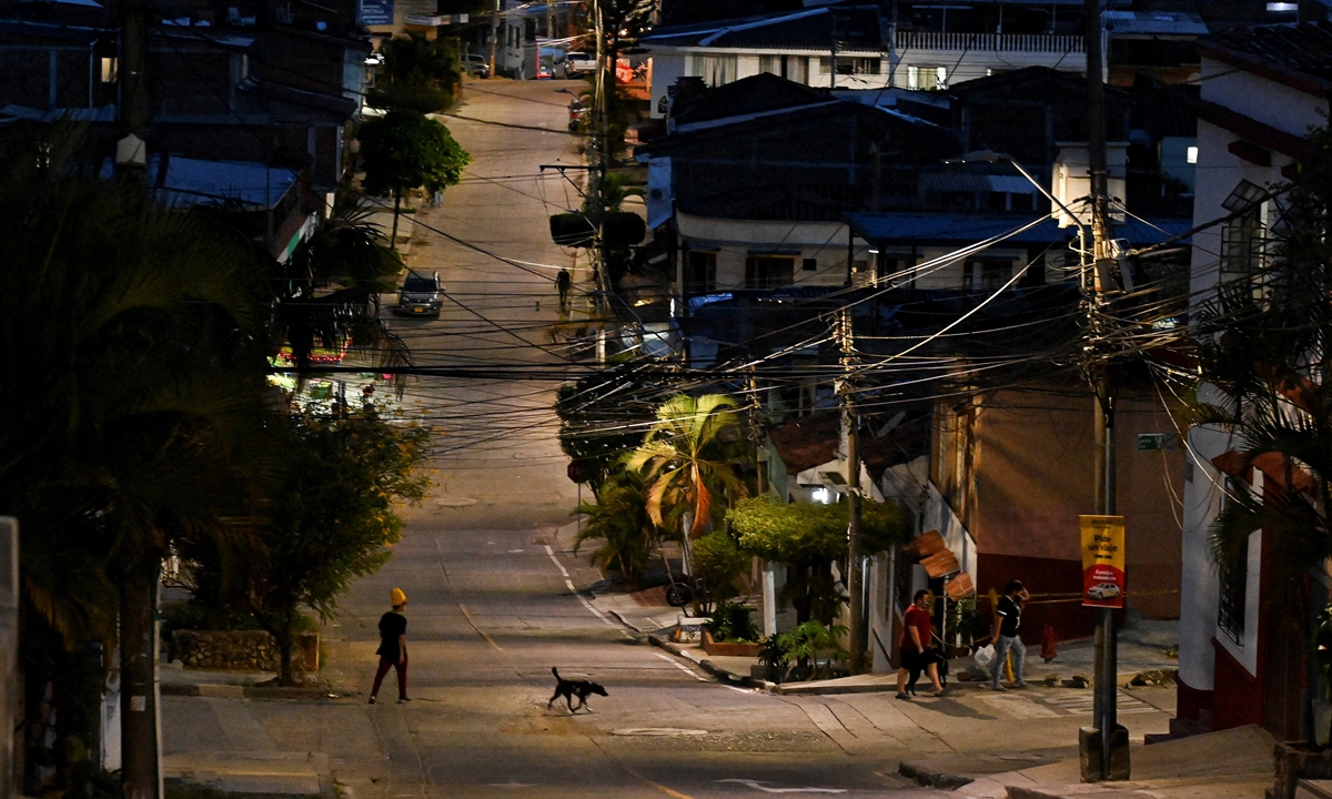 A man walks with his dog along an empty street in Cali, Colombia on Saturday, during a curfew imposed by the government to help curb infections of COVID-19, as weekend partial lockdown takes effect in four Colombian cities. In recent weeks, the Colombian government has imposed, and then tightened a series of restrictions to stem a third wave of infections. Photo: AFP