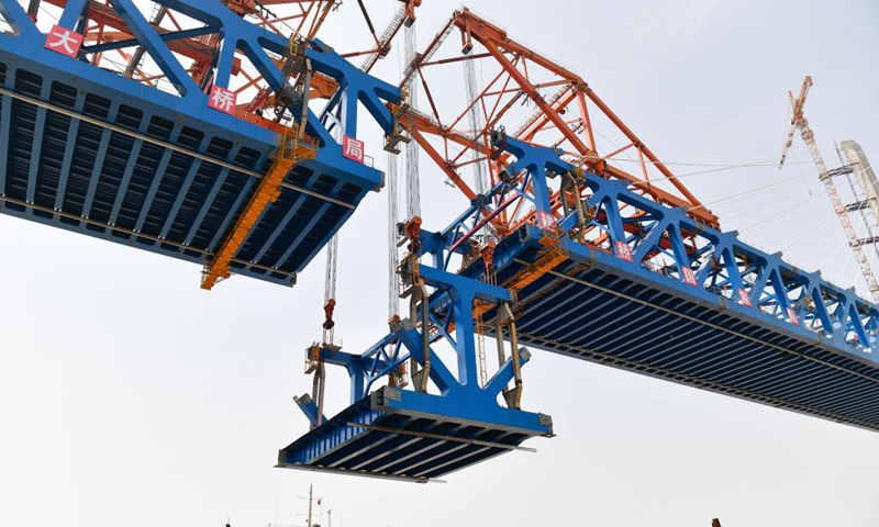 Photo taken on April 17, 2021 shows the last piece of steel beam being hoisted at the construction site of the Jiaojiang grand bridge, a key project of the Hangzhou-Shaoxing-Taizhou inter-city railway, in east China's Zhejiang Province. As the last piece of steel beam was hoisted and installed, the Jiaojiang grand bridge successfully joined together on Saturday.(Photo: Xinhua)