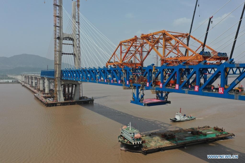 Photo taken on April 17, 2021 shows the last piece of steel beam being hoisted at the construction site of the Jiaojiang grand bridge, a key project of the Hangzhou-Shaoxing-Taizhou inter-city railway, in east China's Zhejiang Province. As the last piece of steel beam was hoisted and installed, the Jiaojiang grand bridge successfully joined together on Saturday.(Photo: Xinhua)