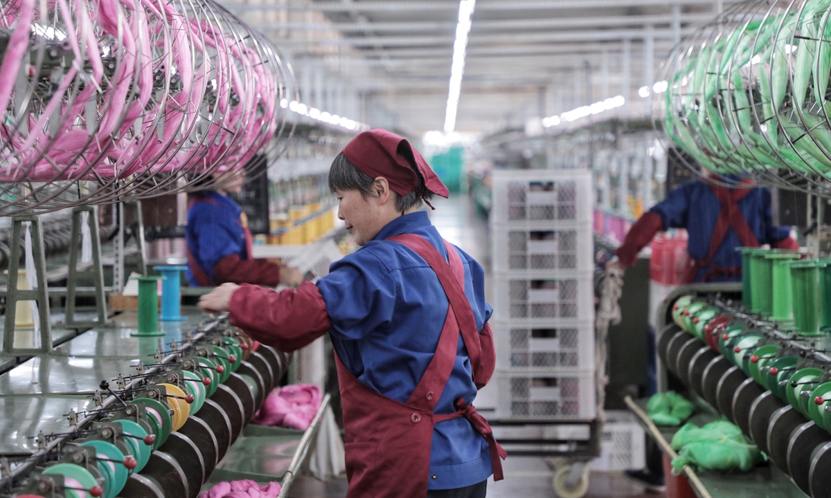 A worker attends a textile machine inside a silk textile factory in Shaoxing, East China's Zhejiang Province. File photo: VCG