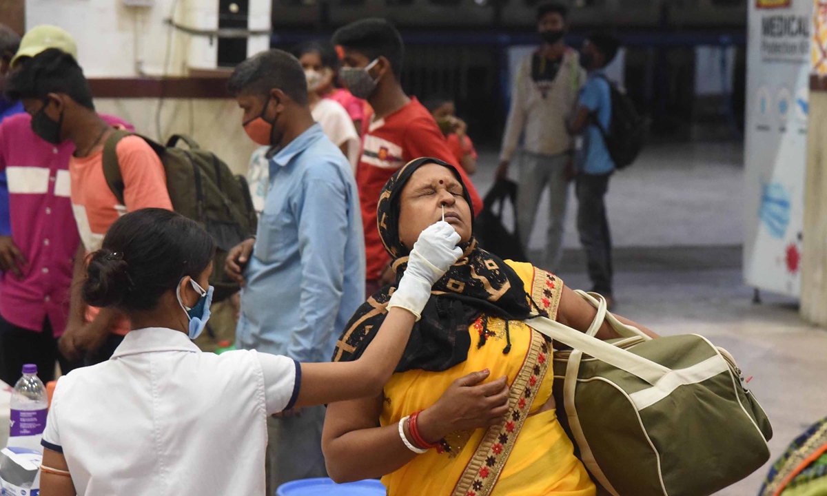 A medical worker tests a passenger at a train station in India on Monday. India’s daily COVID-19 cases jumped to a record 273,810 on Monday as the health system crumbled under the weight of patients, bringing total infections closer to that of the United States, the world’s worst hit country. India’s deaths from COVID-19 rose by a record 1,619 to reach a total of 178,769. Photo: Xinhua